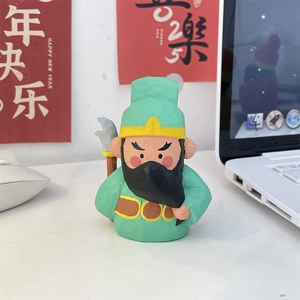 Detailed view of hand-carved Guan Yu figurine with green robe and golden halberd decor