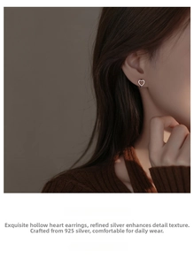 Close-up of 925 sterling silver hollow heart hoop earring worn by a female model