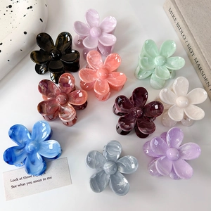Détail de pinces à cheveux en forme de fleurs en acétate avec textures marbrées variées