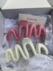 Detail of pink and cream wavy hair claws with a glossy ceramic-like resin finish