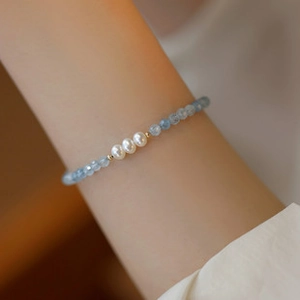 Detailed close-up of handmade beaded bracelet with natural blue stones and white pearls