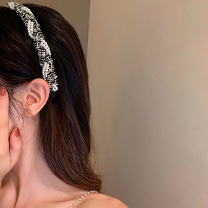Detail of tweed headband with pearls showing woven texture and layered twist design