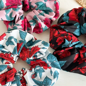 Three elegant fabric scrunchies in pink white and black with red rose floral patterns