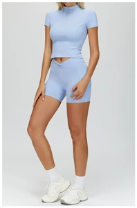 Close-up of light blue yoga set featuring a stand-up collar half-zipper and V-waist shorts