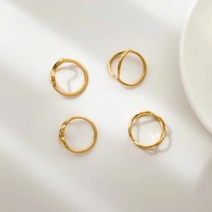 Macro shot of minimalist gold rings with hollow heart and geometric line designs