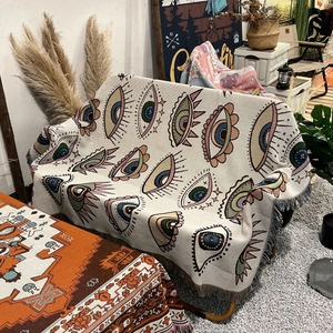 Bohemian woven picnic blanket with colorful eye pattern and fringe for camping decor