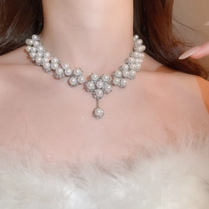 Detailed close-up of a luxury floral pearl choker necklace with a teardrop pearl pendant