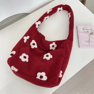 Dettaglio della borsa tote rossa in peluche con trama in pile e motivi a fiori bianchi