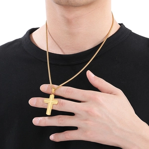 Close-up of golden stainless steel cross pendant necklace worn by a male model