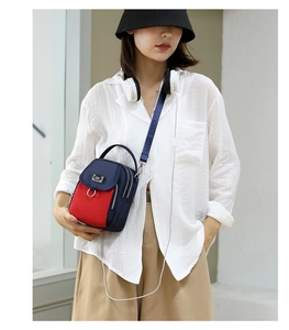 Detail of red and blue nylon crossbody bag with multi-zipper and CHIBAO logo strap