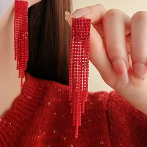 Close-up of red rhinestone fringe earrings showing sparkling crystal tassel details
