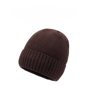 Detailed close-up of dark brown ribbed knit beanie with decorative black patch label