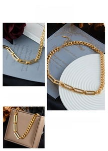 Detailed macro view of asymmetric gold chain necklace featuring thick links and toggle clasp