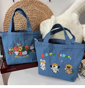 Close-up of blue denim tote bag with cute cartoon animal embroidery and letters