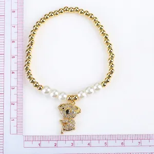 Gold beaded stretch bracelet with white pearls and a micro-pave teddy bear koala pendant