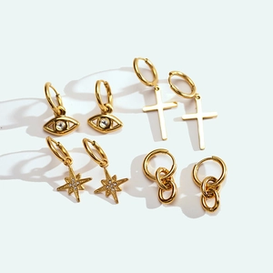 Set of four gold-plated earrings featuring evil eye, cross, and star charms with pavé stones
