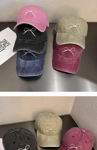 Détail de casquettes vintage en coton lavé avec broderie nœud en plusieurs couleurs