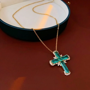 Gold zircon cross pendant necklace with emerald green gemstones and crystal pave details