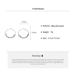 Detailed close-up showing 4.7cm silver hoop earrings with textured diamond-like accents