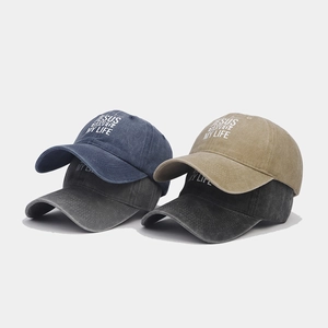 Vista dettagliata di quattro cappellini vintage lavati in blu navy, kaki, grigio e nero con scritte