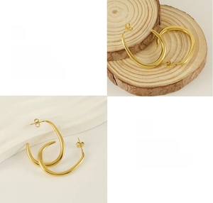 Detail of polished 18K gold plated U-shaped stainless steel earrings with glossy finish
