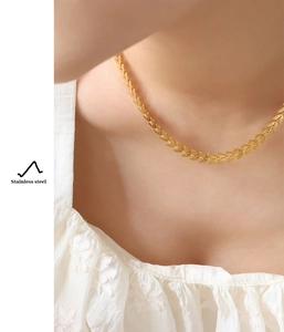 Close-up of 18K gold plated stainless steel leaf chain necklace worn on neck