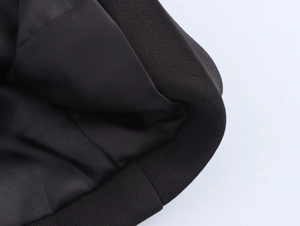 Detail shot of high-quality black fabric texture and premium stitching on a blazer