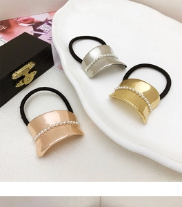 Close-up of alloy hair rings with pearl-inlaid gold and silver metal accents on a plate