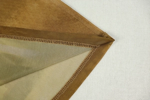 Close-up of tan mesh fabric detailing and reinforced overlock stitching on long dress