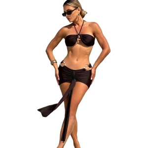 Three-piece black bikini set with halter top and gold ring details on skirt wrap