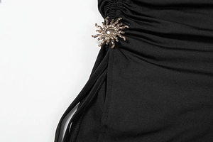 Détail du cordon de serrage avec pendentif soleil doré sur robe noire