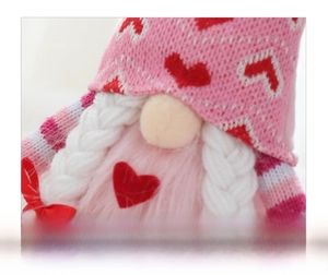 Dettaglio dello gnomo rosa di San Valentino con cappello a cuori e trecce bianche