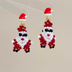 Detail of handmade beaded Santa Claus earrings with a red bow and festive crystal accents
