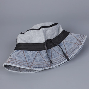 Detail of blue denim bucket hat with decorative black ribbon and contrast stitching