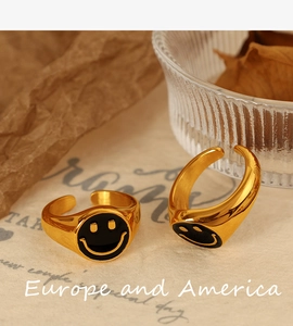 Detail of 18K gold-plated smiley face ring with black enamel drip oil finish