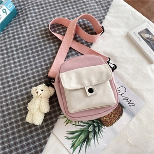 Détail du sac bandoulière en toile rose avec sangle réglable et breloque ours en peluche