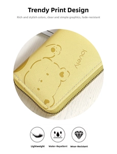 Macro shot of yellow leather accordion wallet with cute bear print and metal zipper