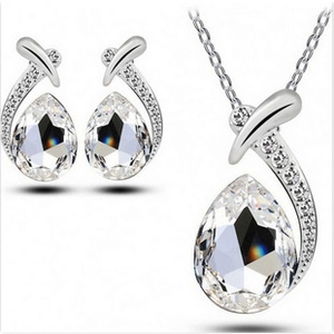 Detailed view of silver cross necklace and waterdrop crystal earrings jewelry set