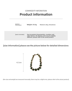 Macro shot of vintage style gold necklace with green rhinestones and flower pattern