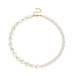 Detail of baroque pearl necklace with heart-shaped shells and gold beads on white background