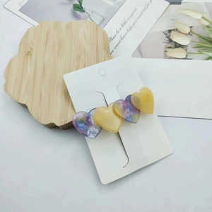Detail of floral and cream acetate heart hair clips on Fashion Jewelry display card