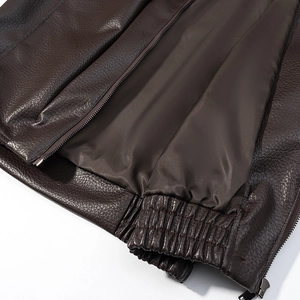 Detailed close-up of dark brown PU leather jacket featuring ribbed elastic hem and inner lining