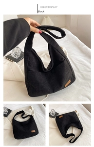 Detail of black corduroy tote bag showing large capacity and side brown leather logo tag