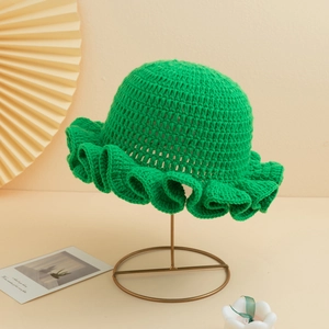 Detail view of handmade crochet knit sun hat with vibrant green ruffles on metal stand