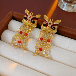 Dettaglio di orecchini vintage leone con nappe rosse e cristalli in scatola regalo