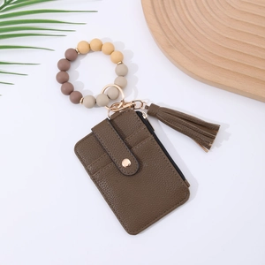 Detail of dark brown leather card holder with silicone bead wristlet and gold hardware