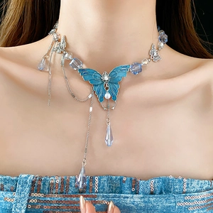Détail du collier papillon bleu avec gouttes de cristal et perle sur le cou du modèle