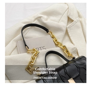 Detail showing the comfortable leather and gold chain shoulder strap on a black embossed bag