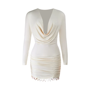 Détail d'une robe crème à manches longues avec col en V, fronces et franges à paillettes