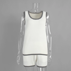 Close-up of white knitted set with grey contrast piping on U-neck and hem detail